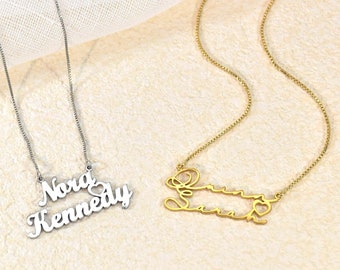 May include: Two personalized necklaces with names and a heart charm. The top necklace is silver with the names "Nora Kennedy" and the bottom necklace is gold with the name "Sarah".