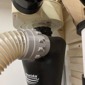 May include: A black dust collection system with a white Oneida Air Systems logo and the text "Super Dust Deputy". The system is mounted to a wall and has a clear hose attached to it.