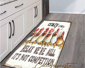 May include: A rectangular kitchen rug featuring a row of cartoon chickens with red combs and yellow feet. The rug has the words "crazy crazy", "RELAX WE'RE ALL", and "IT'S NOT COMPETITION" printed on it. The rug is placed on a wooden floor.