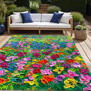 May include: A colorful floral area rug with a green background and a variety of flowers in shades of pink, purple, yellow, orange, and blue. The rug is made with a textured, brushstroke-like design.