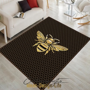 May include: A black and gold area rug with a honeycomb pattern and a large gold bee in the center.