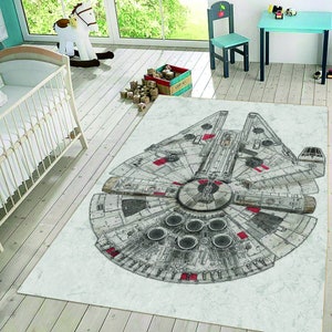 Puede incluir: Una alfombra blanca y gris con una ilustración en blanco y negro del Millennium Falcon, la nave espacial de Star Wars. La nave espacial está delineada en rojo.