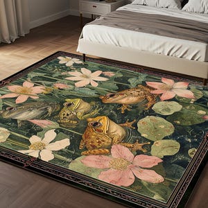 Puede incluir: Alfombra rectangular con una escena de estanque con ranas, nenúfares y flores rosas y blancas. La alfombra tiene un fondo verde oscuro y un borde decorativo. La alfombra está colocada sobre un suelo de madera en un dormitorio.
