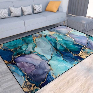 May include: Abstract area rug with a blue, green, and gold marble design. The rug has a modern and contemporary style.