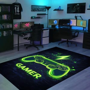 Puede incluir: Una alfombra de juego negra y verde con un mando de videojuego verde brillante y la palabra "GAMER" en una fuente estilizada.