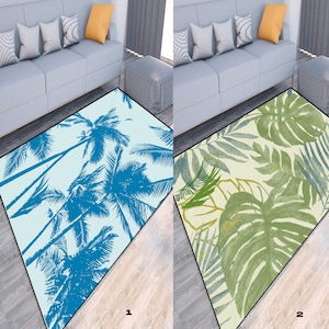 Op de afbeelding: Twee verschillende vloerkleden met tropische ontwerpen. Het eerste vloerkleed heeft een lichtblauwe achtergrond met blauwe palmbomen. Het tweede vloerkleed heeft een lichtbeige achtergrond met groene en bruine tropische bladeren.