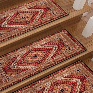 May include: Red and tan stair treads with a geometric pattern. The treads feature a central diamond design with intricate detailing and a border. The stair treads are placed on wooden stairs.