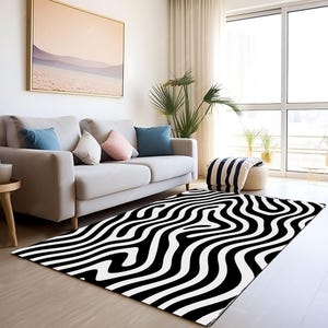 May include: Black and white abstract area rug with wavy lines. The rug is in a living room setting with a white sofa and a plant.