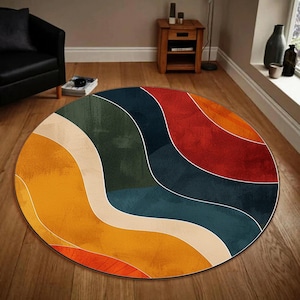 Peut inclure: Un tapis rond avec un motif abstrait coloré. Le tapis présente des lignes ondulées dans des tons de jaune, orange, rouge, bleu, vert et blanc.