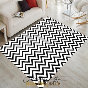May include: Black and white chevron patterned rug. The rug has a geometric design with alternating black and white zigzags.