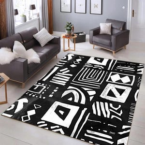 Puede incluir: Alfombra geométrica en blanco y negro con un diseño abstracto moderno. La alfombra presenta una variedad de formas y patrones, incluyendo cuadrados, triángulos y líneas.