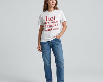 May include: White t-shirt with the text "hot girls watch formula 1" in red. The shirt also features a red graphic of a race car. The model is wearing blue jeans and white trainers.