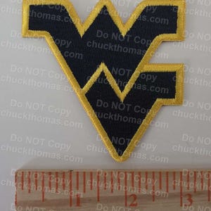 May include: Embroidered patch featuring the letters "WV" in a navy blue color with a gold border. The patch is shaped like a stylized mountain peak. A ruler is placed below the patch. The text "Do NOT Copy chuckthomas.com" is repeated throughout the image.