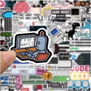 Peut inclure: Un autocollant repr&eacute;sentant un robot de dessin anim&eacute; devant un ordinateur avec le texte "I'M NOT A ROBOT". Le robot est gris avec une lumi&egrave;re rouge sur la t&ecirc;te. L'autocollant est entour&eacute; d'autres autocollants sur le th&egrave;me de la technologie, dont "DARK MODE".