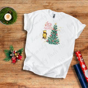 Camiseta navideña vintage de Winnie the Pooh: diseño de árbol navideño con espiral dorada y frase festiva. Camiseta navideña nostálgica, inspirada en Disney.