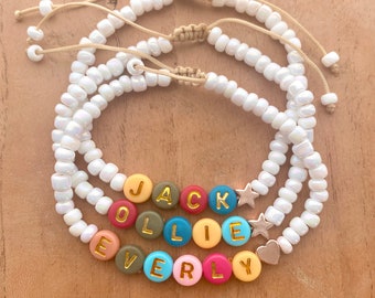 Personalized name bracelet with colored letter beads. Finished with stainless steel heart, star, butterfly or bead.