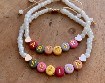 Bracciale con nome personalizzato con perline colorate. Rifinito con cuore, stella, farfalla o perlina in acciaio inossidabile.