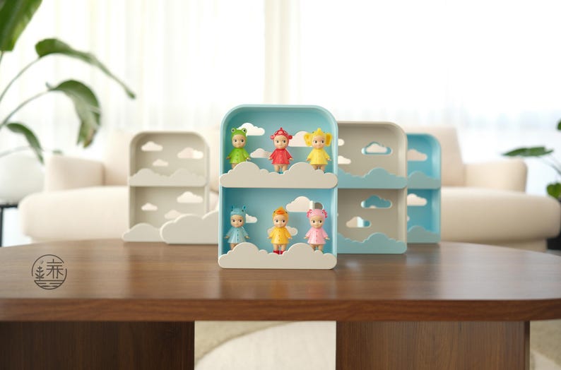 K&ouml;nnte beinhalten: Ein dekoratives Regal mit Wolkenmotiv, das kleine Puppen pr&auml;sentiert. Die Regale sind hellblau und wei&szlig;, mit wolkenf&ouml;rmigen Ausschnitten. Die Puppen sind in verschiedenen Farben gehalten, darunter Gr&uuml;n, Rot, Gelb und Rosa. Auf einem dunkelbraunen Tisch.