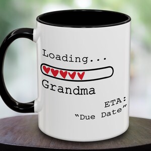 May include: White ceramic mug with a black handle and rim. The mug features the text "Loading... Grandma" with a progress bar of red hearts and the text "ETA: Due Date".
