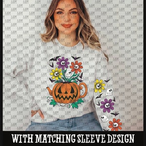 May include: A white long-sleeved shirt with a pumpkin-shaped teapot design. The teapot is decorated with a jack-o'-lantern face and surrounded by colorful flowers and bats. The text "WITH MATCHING SLEEVE DESIGN" is printed below the design.