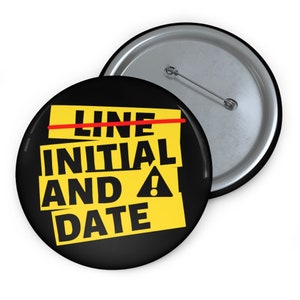 May include: A black and yellow button with the text "INITIAL AND DATE" with a red line through the word "LINE".