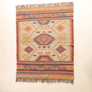 May include: A colorful, geometric patterned rug with a fringe border. The rug is made of natural fibers and has a cream background with red, blue, yellow, and green accents.