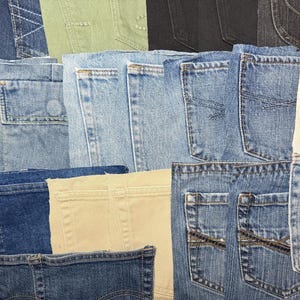 May include: A collection of assorted denim and cotton fabric pockets arranged in a grid. The pockets feature various shades of blue, black, beige, and off-white, showcasing different stitching patterns, pocket shapes, and fabric textures.