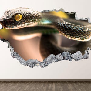 May include: A 3D wall art piece depicting a snake breaking through a wall. The snake has detailed scales in green and brown, with a yellow eye. The hole's edges are jagged, with grey stone fragments, creating a realistic effect.