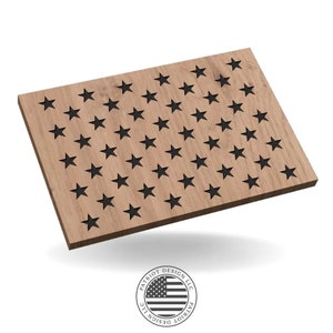May include: A wooden plaque with a light brown finish, featuring a design of black stars arranged in rows. The plaque has a rectangular shape and a beveled edge. The logo of "Patriot Design LLC" is at the bottom.