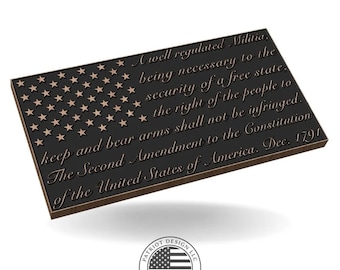 May include: A rectangular plaque featuring the American flag design with stars and stripes. The text of the Second Amendment is engraved on the plaque. The plaque is dark gray with bronze-colored accents and a logo.