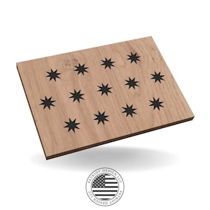 Puede incluir: Una tabla de madera marrón claro con un patrón de estrellas negras. Las estrellas están espaciadas uniformemente sobre la superficie. La tabla tiene forma rectangular y está ligeramente inclinada. El logotipo "PATRIOT DESIGN LLC" está en la esquina inferior derecha.