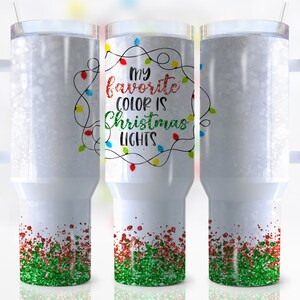 May include: White tumbler with a green and red glitter bottom. The tumbler has a handle and says "My favorite color is Christmas lights" with a string of colorful lights around the text.