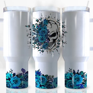 May include: Three white stainless steel travel mugs with a blue floral design and a skull with blue roses on the middle mug.