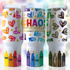 Puede incluir: Vaso blanco con asa y tapa, con un diseño de corazones coloridos y purpurina dorada. El texto "CHAOS COORDINATOR" se muestra en un marco dorado. La parte inferior del vaso tiene una fila de crayones.