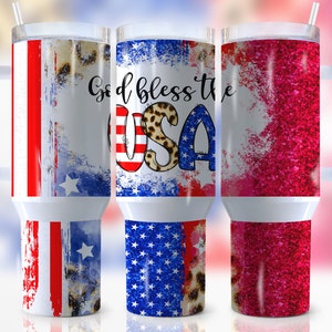 May include: Three stainless steel tumblers with handles and lids. The tumblers are decorated with a red, white and blue American flag design, a red, white and blue American flag design with leopard print accents, and a pink glitter design. The tumblers are all on a white surface.