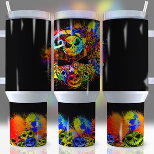 Pu&ograve; includere: Tre bicchieri in acciaio inossidabile con sfondo nero e schizzi di vernice colorata. Il bicchiere centrale presenta una grafica colorata di Jack Skellington de The Nightmare Before Christmas.