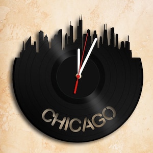 Könnte beinhalten: Schwarze Schallplattenuhr mit einer Silhouette der Skyline von Chicago und dem Wort "CHICAGO" auf dem Zifferblatt.