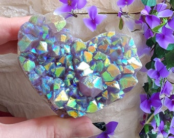 May include: A heart-shaped amethyst crystal with iridescent rainbow colors. The crystal is made up of many smaller crystals that are clustered together.
