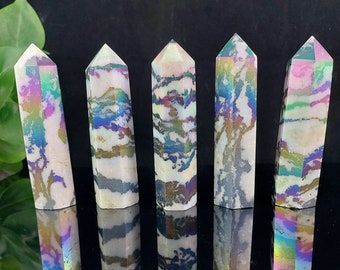 May include: Five iridescent white and grey crystal points with a rainbow sheen. The points are arranged in a row on a black surface.