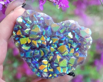 May include: A heart-shaped iridescent crystal with a blue, green, and gold color scheme. The crystal is made up of many smaller crystals that are clustered together.