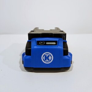 Op de afbeelding: Een blauwe en zwarte batterijpack met een K-logo en een batterijniveau-indicator.
