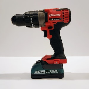 May include: A red and black Bauer 20V Lithium cordless drill with a black chuck and a green battery pack. The drill has a black handle and a red trigger. The battery pack is labeled 2.5Ah 20V Lithium-Ion.