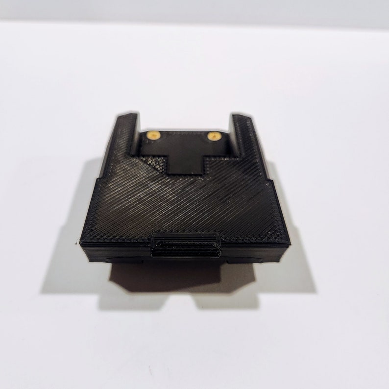 May include: A black 3D printed plastic mount with two gold screws.