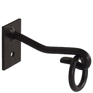 May include: A matte black metal wall hook featuring a rectangular mounting plate with a single circular screw hole. The hook extends outward with a bent arm that terminates in a decorative looped knot design, providing a sturdy point for hanging.