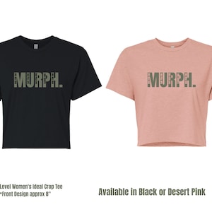May include: Two cropped t-shirts, one black and one pink, with the word "MURPH." printed in green on the front. The text is made up of smaller words, creating a unique design.