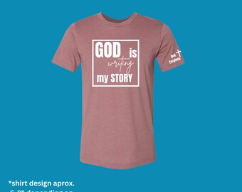 God is writing my story. Unisex T-shirt by And Forgiven.