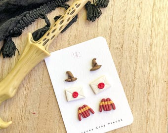 May include: A set of six Harry Potter themed clay earrings. The earrings feature a Hogwarts hat, a letter with a red wax seal, and a Gryffindor sweater.