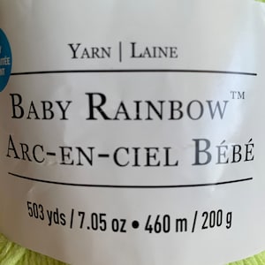 May include: A skein of light green yarn labeled "Baby Rainbow Arc-en-Ciel Bébé" with a yarn weight of 503 yards / 7.05 ounces or 460 meters / 200 grams.