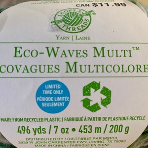 May include: A skein of green, white, and brown yarn labeled "Eco-Waves Multi" and "&Eacute;covagues Multicolores". The yarn is made from recycled plastic and is 496 yards / 7 ounces or 453 meters / 200 grams.