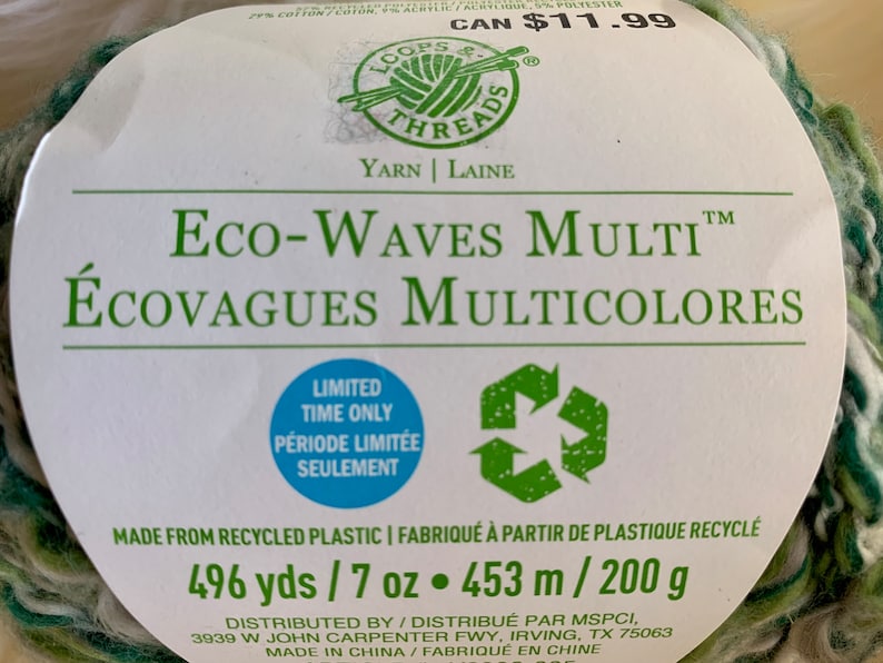 May include: A skein of green, white, and brown yarn labeled "Eco-Waves Multi" and "&Eacute;covagues Multicolores". The yarn is made from recycled plastic and is 496 yards / 7 ounces or 453 meters / 200 grams.